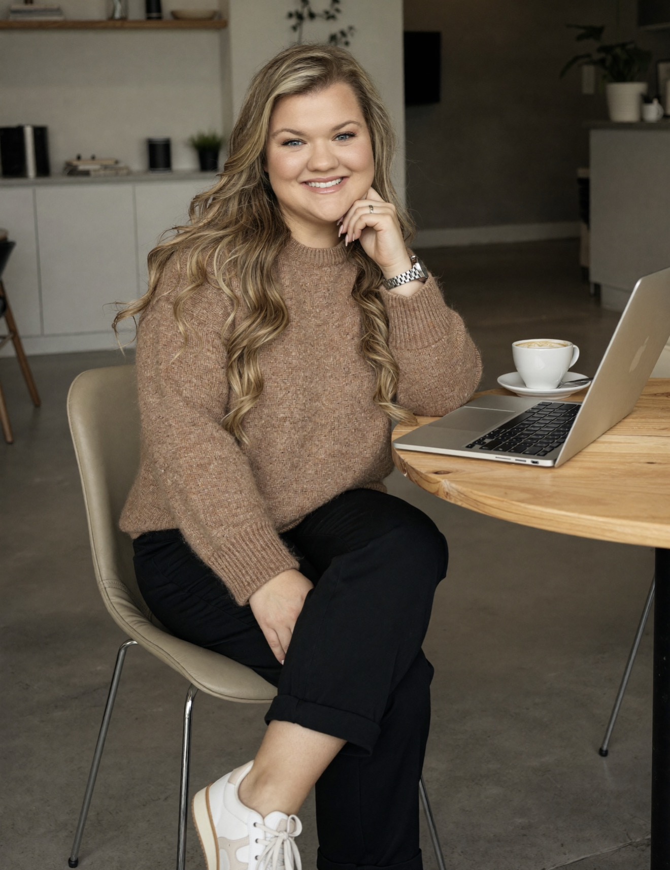 AI Twin in a camel sweater working on a laptop with coffee